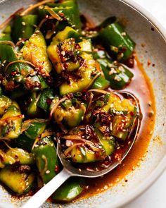 a white bowl filled with green vegetables and sauce