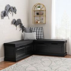 a black bench sitting on top of a wooden floor next to a white rug and window