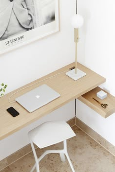 a desk with a laptop, mouse and other items on it next to a framed photograph