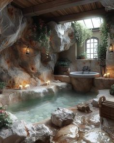 an indoor hot tub surrounded by rocks and candles