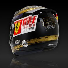 a helmet with gold and red designs on it's side, sitting on a black surface