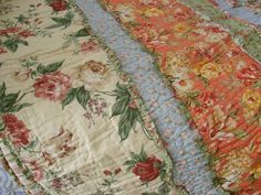 three bedspreads with flowers on them laying next to each other