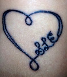 a heart shaped tattoo with the word love on it