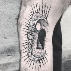 a man's leg with a black and white tattoo design on the side of his arm