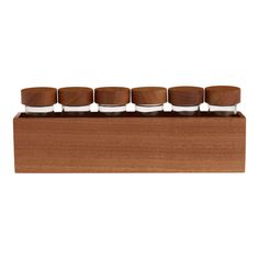 six wooden and metal containers sitting on top of a wooden box with four different sized lids