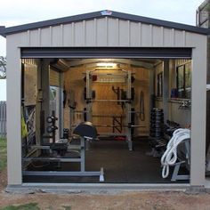 the inside of a garage with an open door and lots of exercise equipment in it