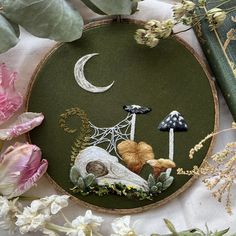 an embroidery project with flowers and mushrooms on it