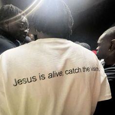 a group of people standing next to each other in front of a camera with the words jesus is alive, catch the vision on it