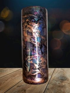 a glass vase sitting on top of a wooden table next to a blurry background