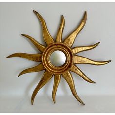 a sun shaped mirror hanging on the wall