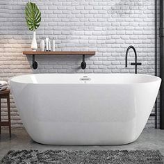 a white bath tub sitting on top of a bathroom floor next to a brick wall