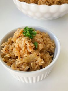 a bowl filled with rice next to another bowl full of food on top of a table