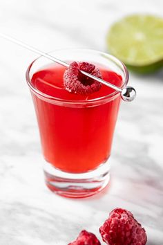 raspberry punch in a glass with two limes on the side