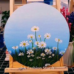 an easel with daisies painted on it