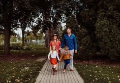 three adults and two children walking down a path