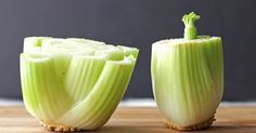 two pieces of celery sitting on top of a wooden table next to each other