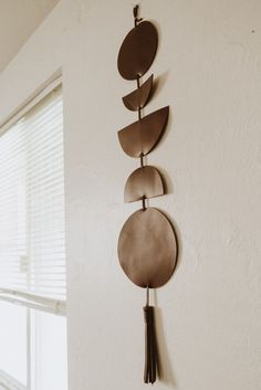 three metal discs hanging on the wall next to a window