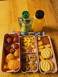 the lunch box is full of fruit, crackers, and cookies with orange juice