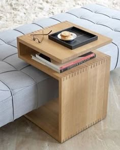 a coffee table with a magazine rack on it and a couch in the back ground