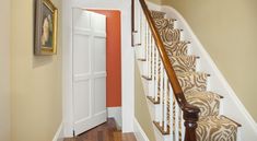 the stairs are decorated with zebra prints and wooden handrails, along with an orange accent wall