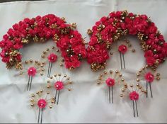 red and gold flower hair combs on a white sheet with pearls in the middle