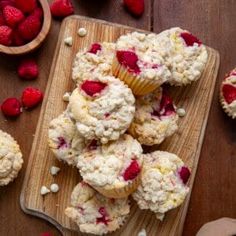 muffins with strawberries and white chocolate chips on a cutting board