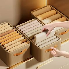 a woman is reaching for some items in a suitcase that are on the floor next to another drawer