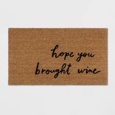 a door mat with the words hope you brought wine written in black ink on it