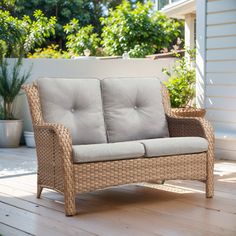 a wicker couch sitting on top of a wooden deck