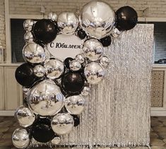 black and silver balloons are hanging from the ceiling in front of a sign that reads c douceauxe