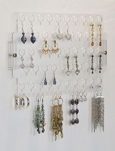 a wall mounted jewelry rack with several pairs of earrings