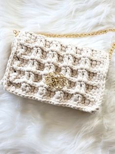 a white crocheted purse sitting on top of a furnishing covered floor