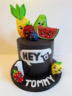 there is a cake made to look like a hat with fruit on top and the words hey tommy