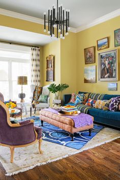 a living room filled with furniture and pictures on the wall above it's windows