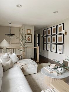 a living room filled with furniture and pictures on the wall