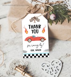 a thank you card with a red car on it next to a key and gift bag