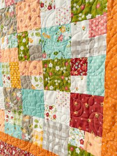 a colorful quilt is hanging on the wall