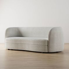 a white couch sitting on top of a hard wood floor