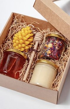 two jars of jam in a box with corn on the cob