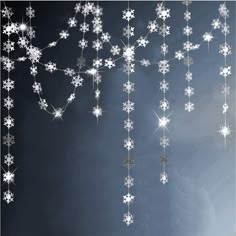 snowflakes are hanging from the ceiling in front of a black background with white stars