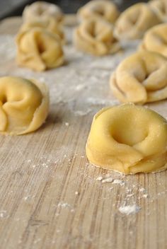 some doughnuts are sitting on a wooden table and ready to be baked in the oven