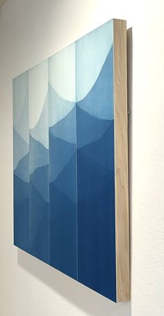 a blue painting hanging on the side of a wall