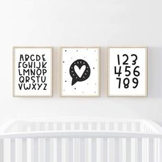 three black and white posters on the wall above a crib in a baby's room