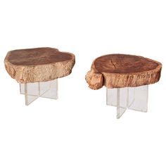 two tables made out of wood and clear acrylic bases, one with a tree trunk on top