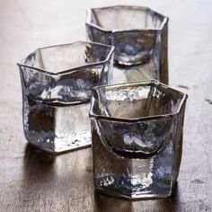 four glass cups sitting on top of a wooden table