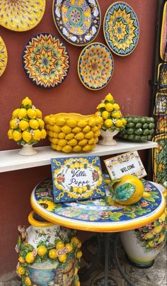 there are many plates and bowls on the shelf in front of this storefront display