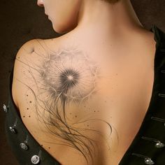 the back of a woman's shoulder with a dandelion tattoo