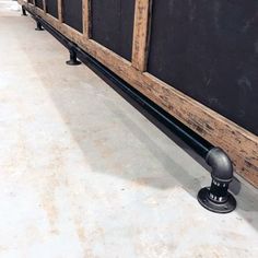 a metal ball sitting on the ground next to a blackboard with wooden slats