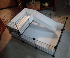 a large white box with black wire on the bottom and sides is sitting in front of a bookcase