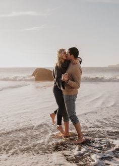 a man and woman kissing on the beach